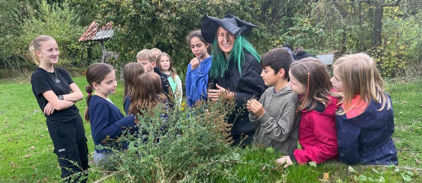 Kinder im Garten mit verkleideter Frau