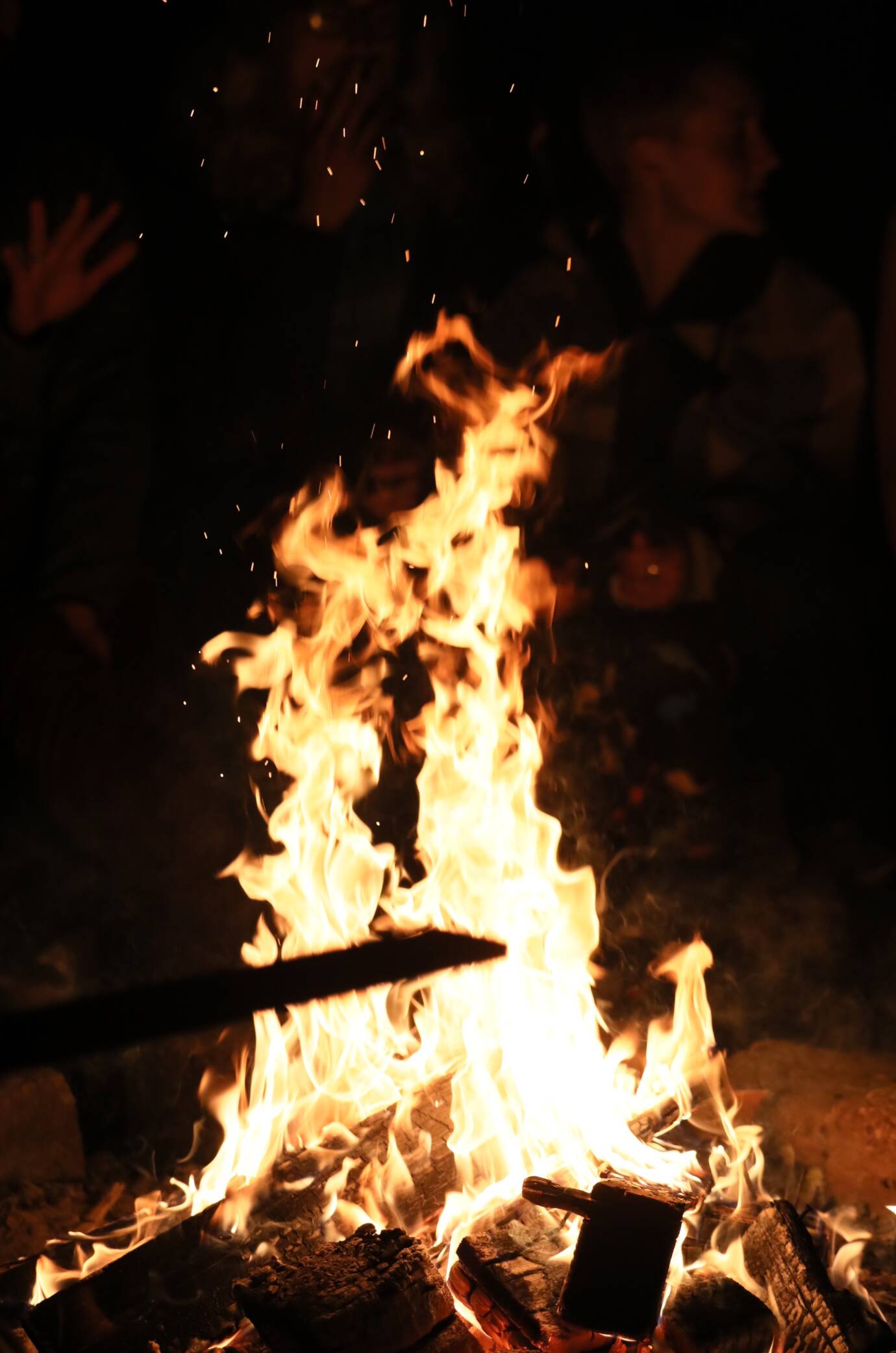 Lagerfeuer in der Dunkelheit mit Flammen und Funken.